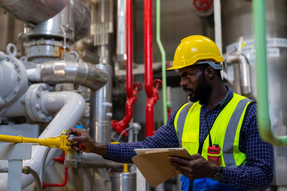 Engineer inspecting valves at a processing facility